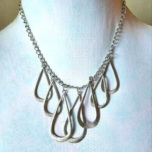 Necklace with multiple teardrop shaped pendants textured silver tone